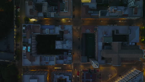 Top-down-footage-of-buildings-and-illuminated-streets-in-night-city.-Low-traffic-in-evening.-Rome,-Italy