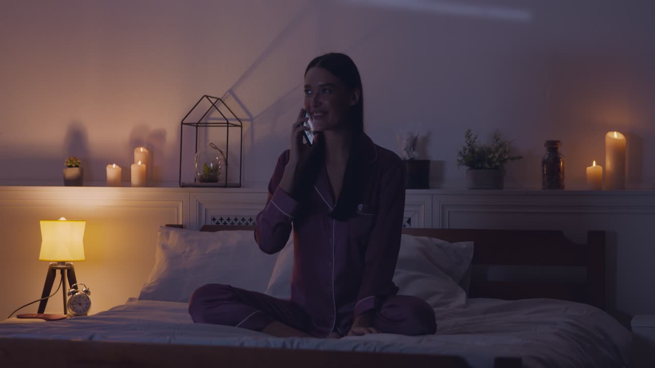 밤에 침대에서 스마트폰을 사용하는 여성