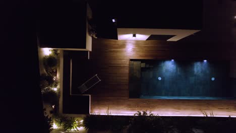 aerial view of a modern house with a pool at night
