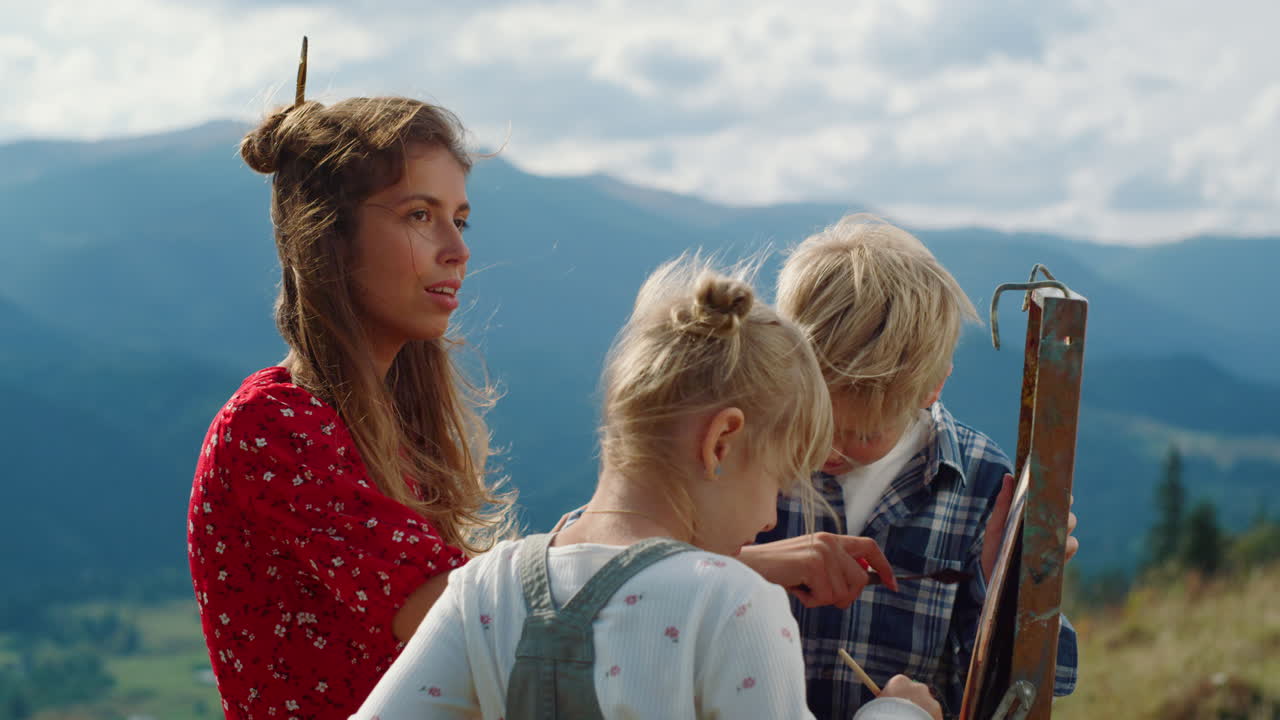 창의적인 가족 그림 산 그림. 클로즈업 어머니 아이들이 자연을 그린다