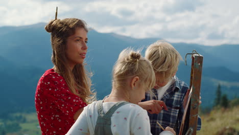 creative family painting mountains picture. closeup mother children draw nature