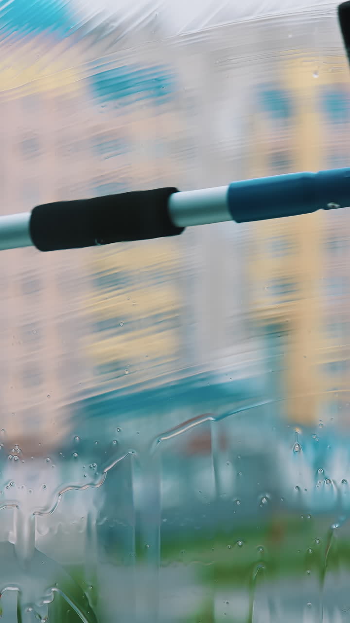 Close up view of cleaning window. Window cleaner working with wet glass window. Vertical video