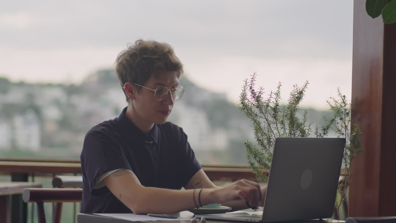 Woman Working on Laptop in Outdoor Cafe on Mountain Peak