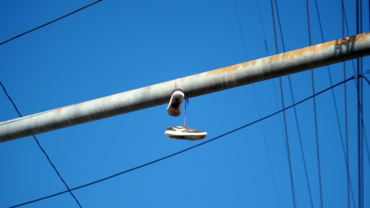 한 의 신발이 4k에서 전화선에 매달려있는 비디오