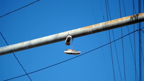 video de un par de zapatos colgado lanzado al cable telefónico en 4k