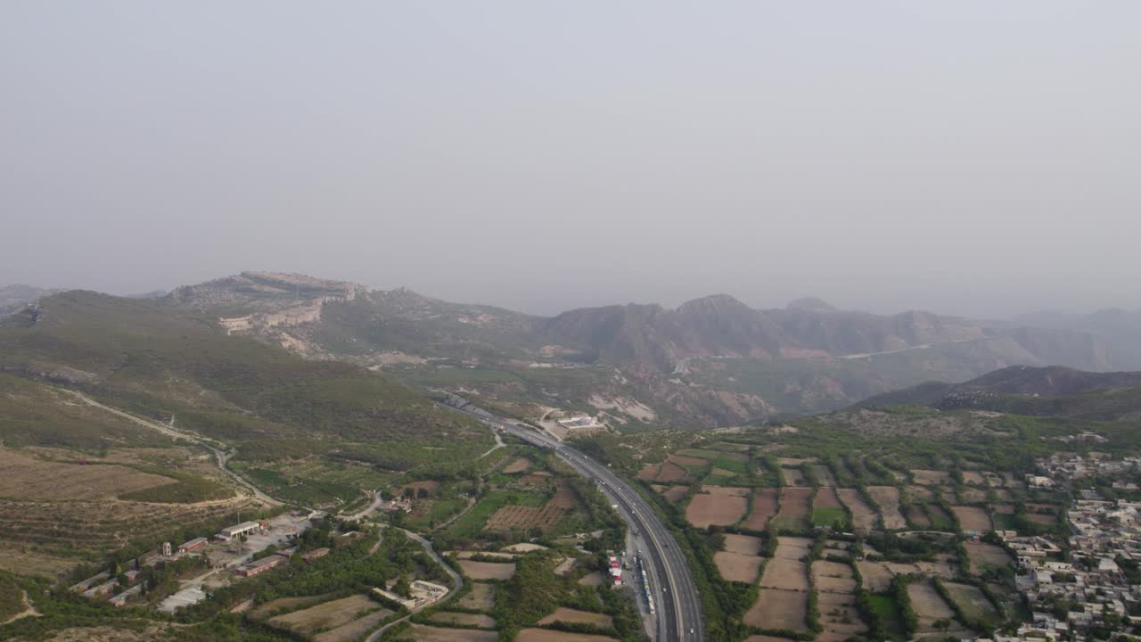 Aerial view of M2 Motorway cutting through fields and hills near Kallar Kahar in the Salt Range. Pakistan