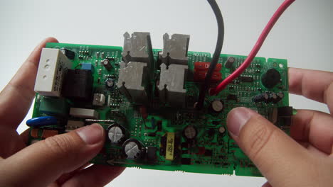 primer plano de un panel de placa de circuito siendo inspeccionado cuidadosamente por un técnico
