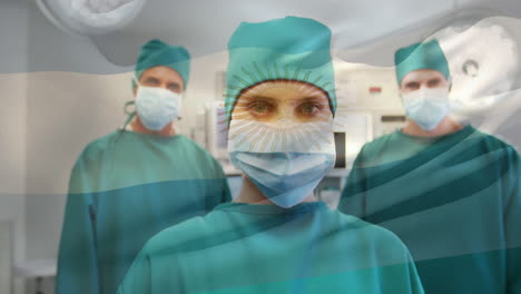 animación de agitar la bandera argentina contra un equipo de cirujanos diversos de pie juntos en el hospital