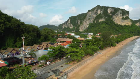 Vista-Aérea-De-Ao-Nang-Con-Playa-De-Arena-Y-Océano-Durante-La-Puesta-De-Sol,-Tailandia---Montañas-Con-Paisaje-Verde