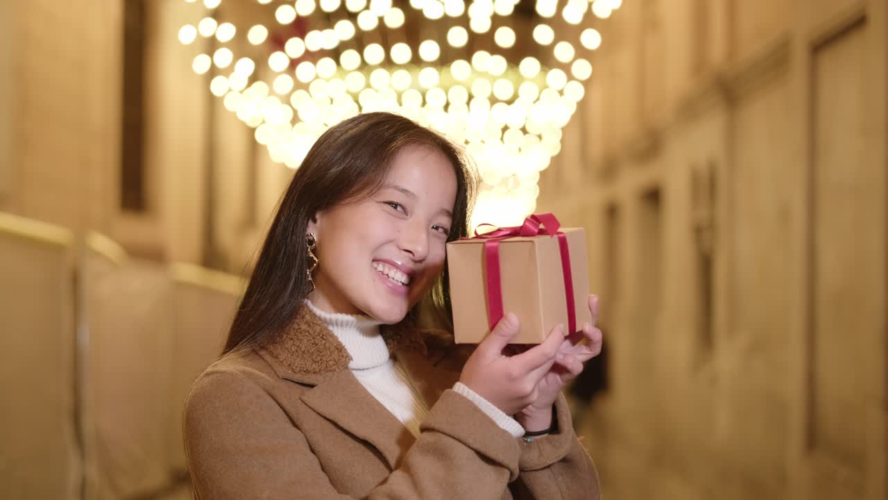 Woman with Gift in Christmas Lights