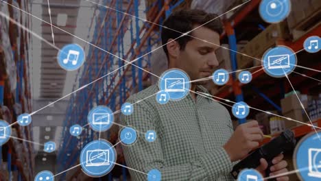 Animation-of-network-of-digital-icons-over-caucasian-male-supervisor-checking-stock-at-warehouse
