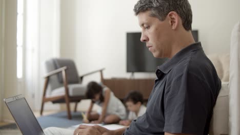 focused dad with laptop working at home