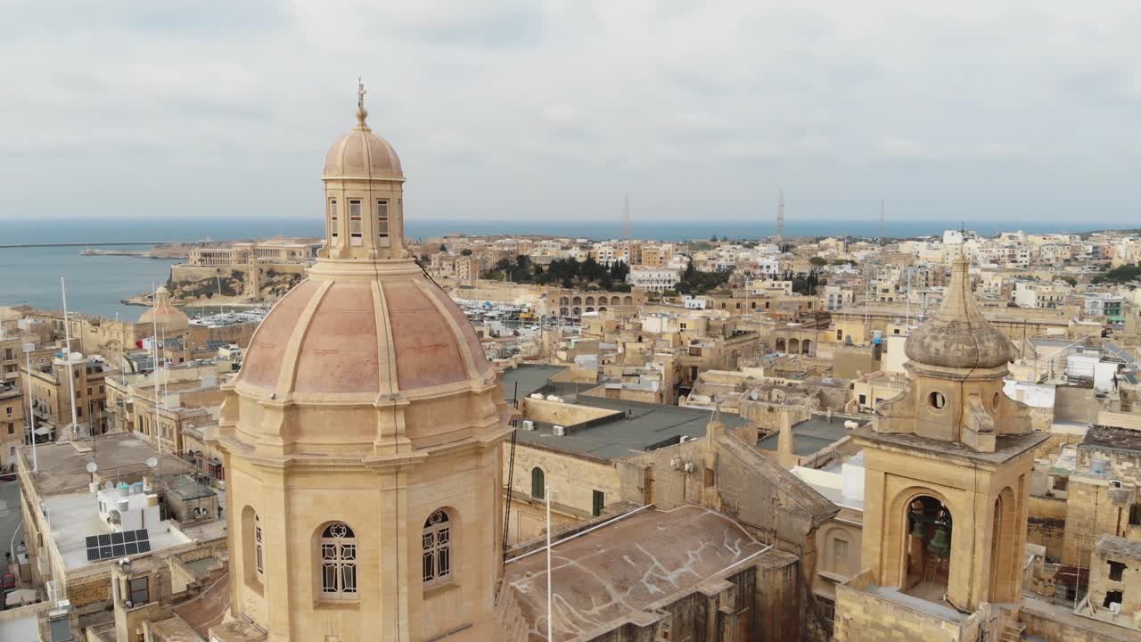 primer plano aéreo de la basílica de senglea que revela el puerto en malta