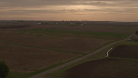 Aerial-of-an-old-country-road-and-farmland-at-sunrise-tracking-right