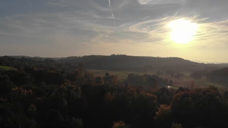 Aerial-view-of-the-beautiful-green-hills-towards-the-sun-in-Odsherred,-Denmark