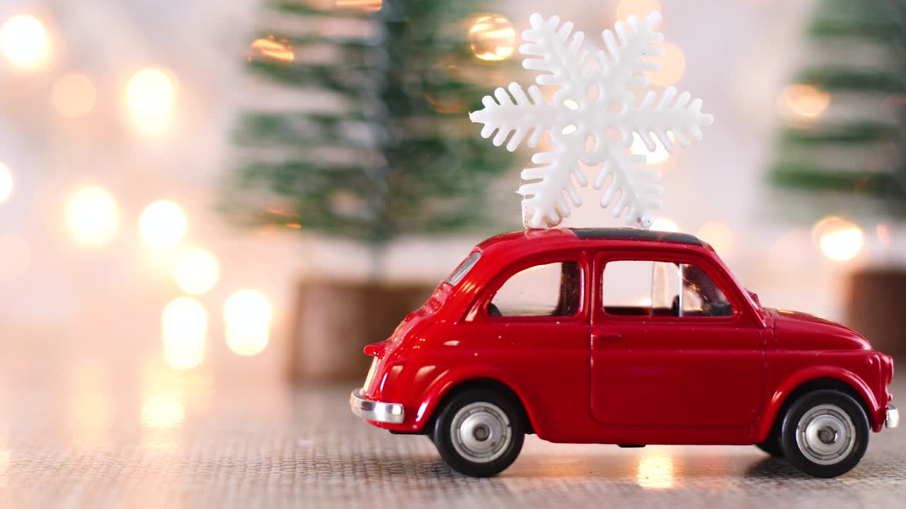 Auto natalizia con fiocco di neve sul tetto e luci intermittenti