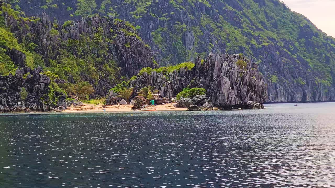 playa tropical oculta y cabaña de madera bajo rocas de piedra caliza, el nido, palawan, filipinas