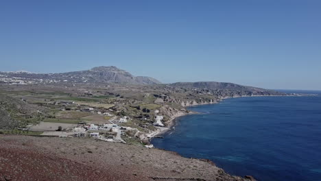 Panning-aerial-shot-of-Greek-island-of-Santorini,-on-bright-sunny-day,-4K