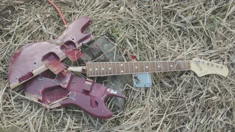 broken red electric guitar on the ground