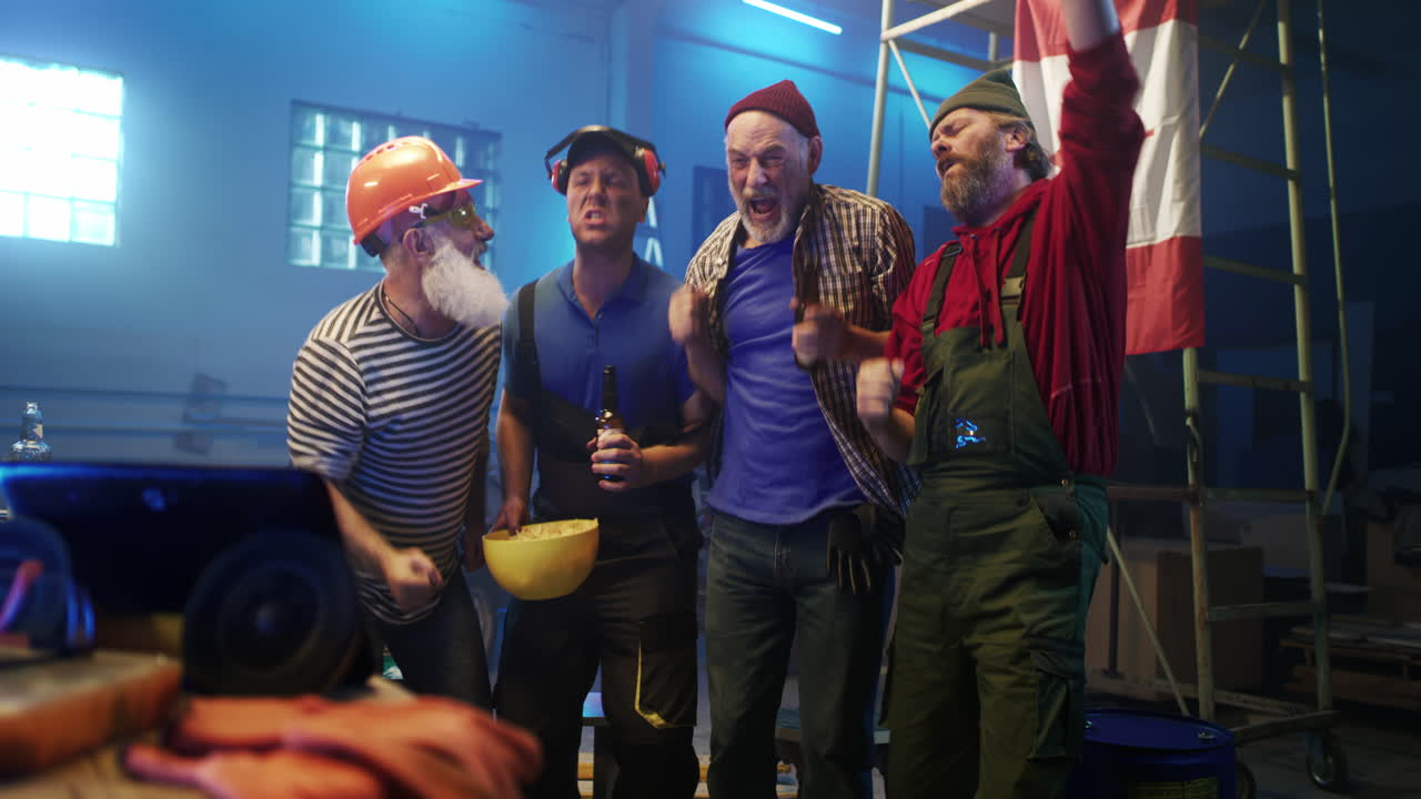 Excited Group of Men Cheering in a Workshop with a Canadian Flag