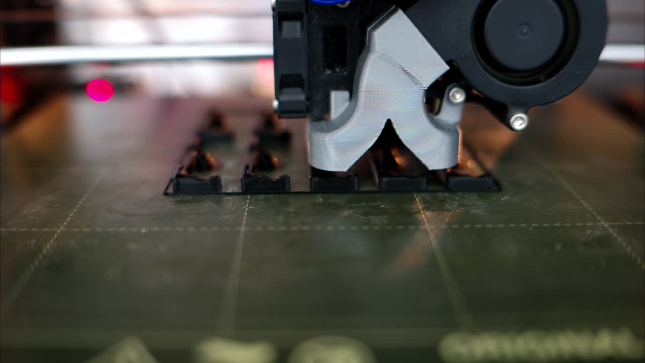 3D printer working assembling a black plastic object at the factory