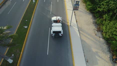 antena de 4k de jeep conduciendo a lo largo de una carretera a través del hermoso paisaje de tulum, méxico a través de la exuberante jungla, el video captura el espíritu aventurero y resistente de explorar tulum en jeep