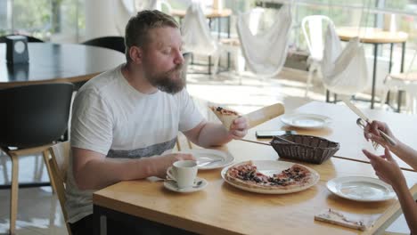 couple eating pizza in a restaurant