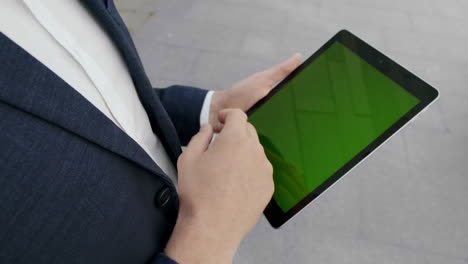 businessman hands using digital tablet in city. male executive texting on pad