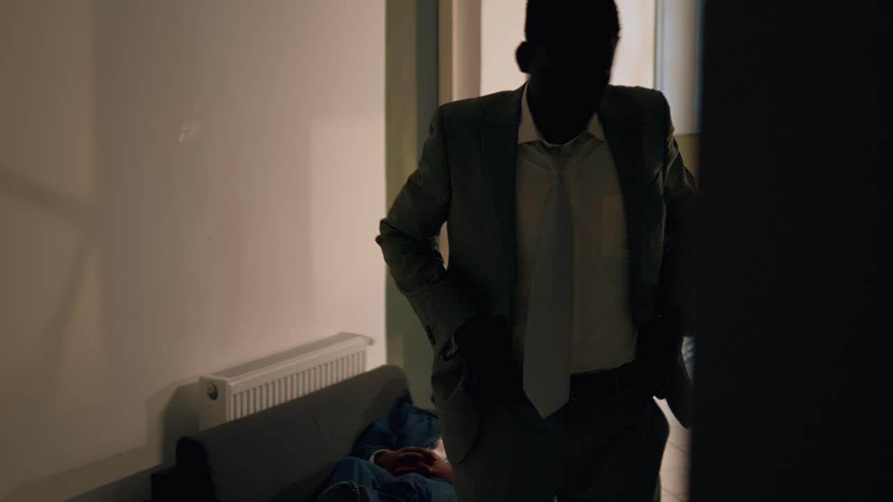 An office scene with a man working and another one sleeping