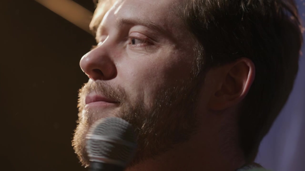 Primo piano di un comico di stand-up che racconta una battuta spiritosa sul palco