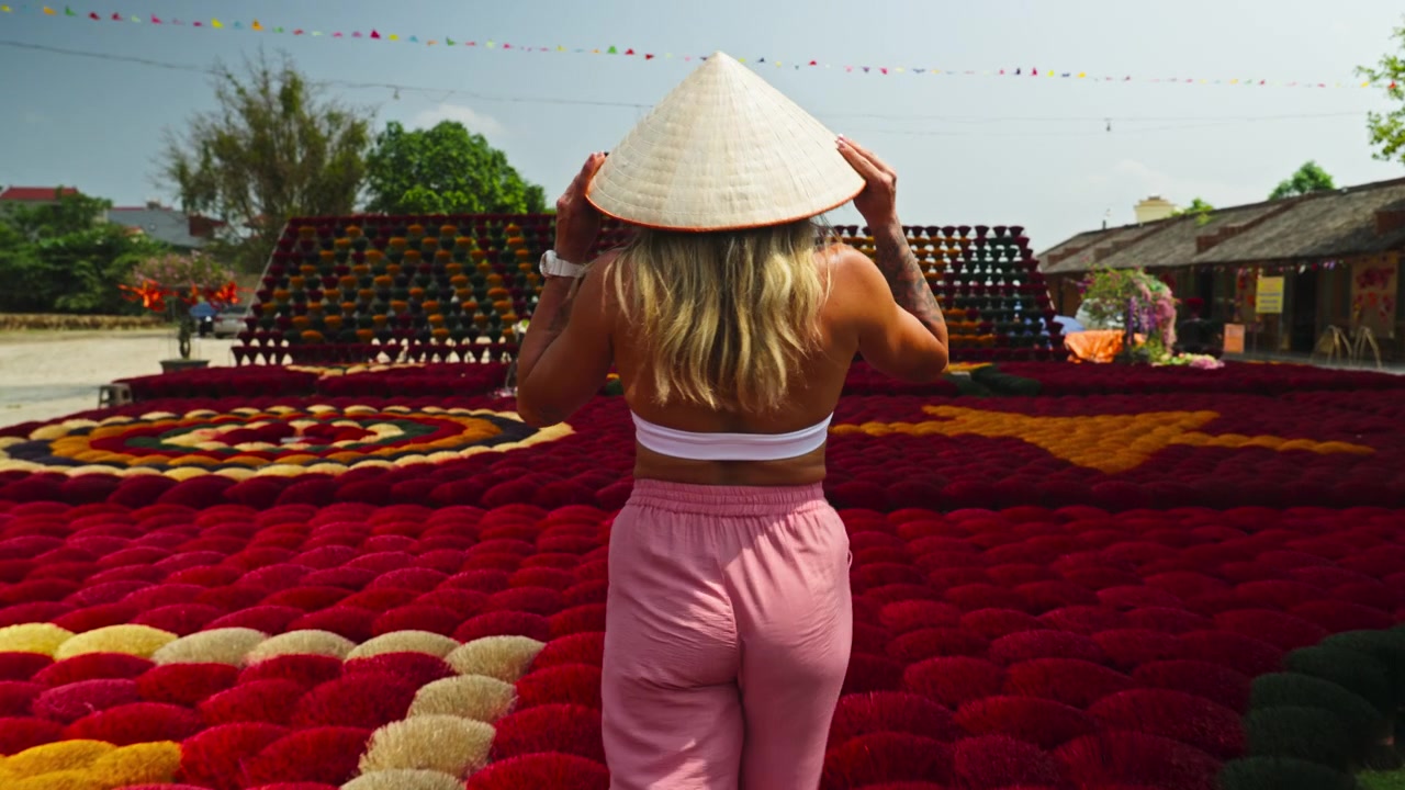 Kvinna i en traditionell Non La-hatt under ett besök i rökelsebyn Quang Phu Cau i Hanoi, Vietnam. - följebild.