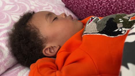 Exotic-two-year-old-african-european-child-sleeping-deeply-in-his-bed