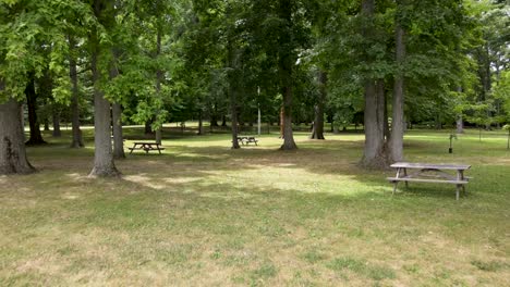 drone flying through a sunny park covered in benches