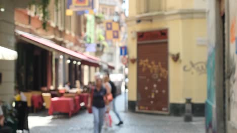 artistic out of focus static shot of people walking a colorful street in torino italy