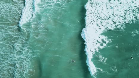 toma de seguimiento de una ola rompiendo a través de un grupo de surfistas