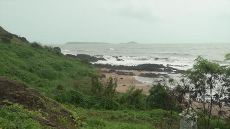 Lush-green-grass-field-in-the-foreground-with-a-rocky-beach-in-the-background