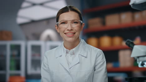 retrato de una mujer médica sonriendo a la cámara con gafas de protección.