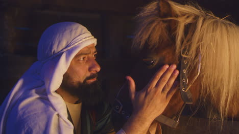 man and horse in stable