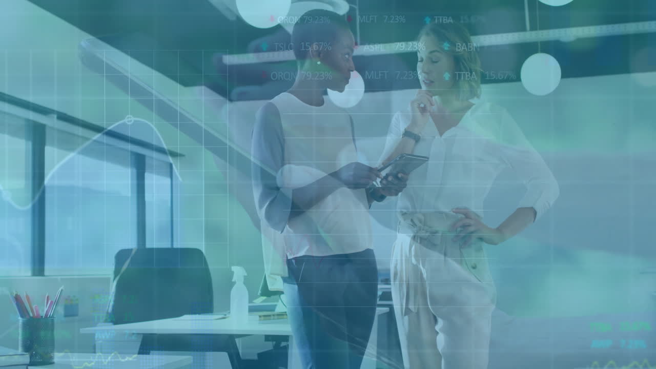 Due donne d'affari che discutono di un'animazione di dati finanziari in un ufficio moderno.