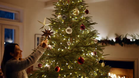 mujer decorando un árbol de navidad