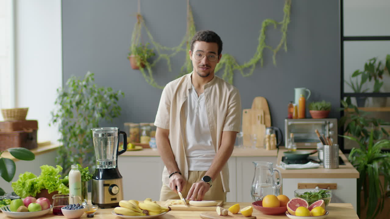 Male Blogger Cutting Fruit for Smoothie and Talking on Camera