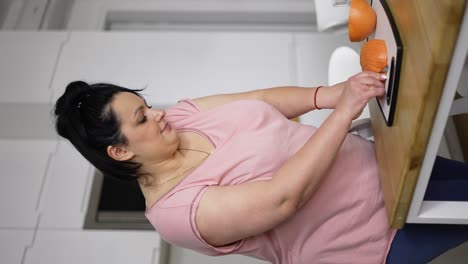 attractive overweight woman preparing healthy meal, cutting grapefruit, closeup