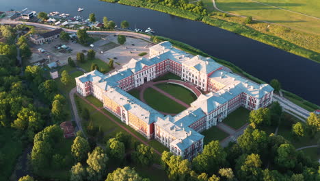 jelgava palace and courtyard on the shore of lielupe river on golden hour sunlight