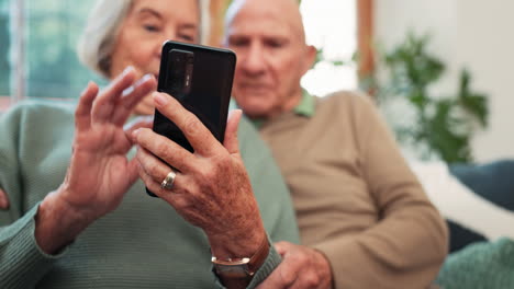 manos, una pareja de ancianos y un teléfono inteligente en casa para