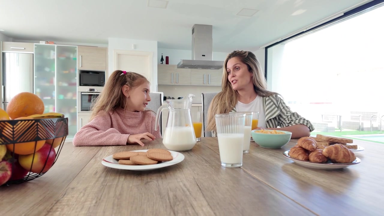 Madre e figlia che parlano durante la colazione a casa