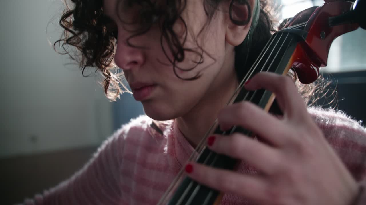 Young Woman Playing Cello with Intense Focus and Backlight