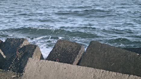 concrete breakwaters. water splash on pier rock. sea waves crashing on rock