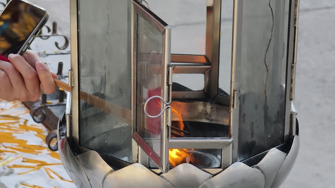 사원 에서 막대기 들 을 들고 향 을 태우는 장치