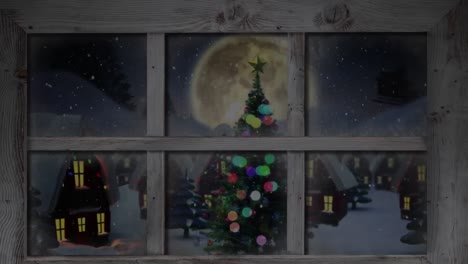 Wooden-window-frame-against-snow-falling-over-christmas-tree-and-houses-on-winter-landscape