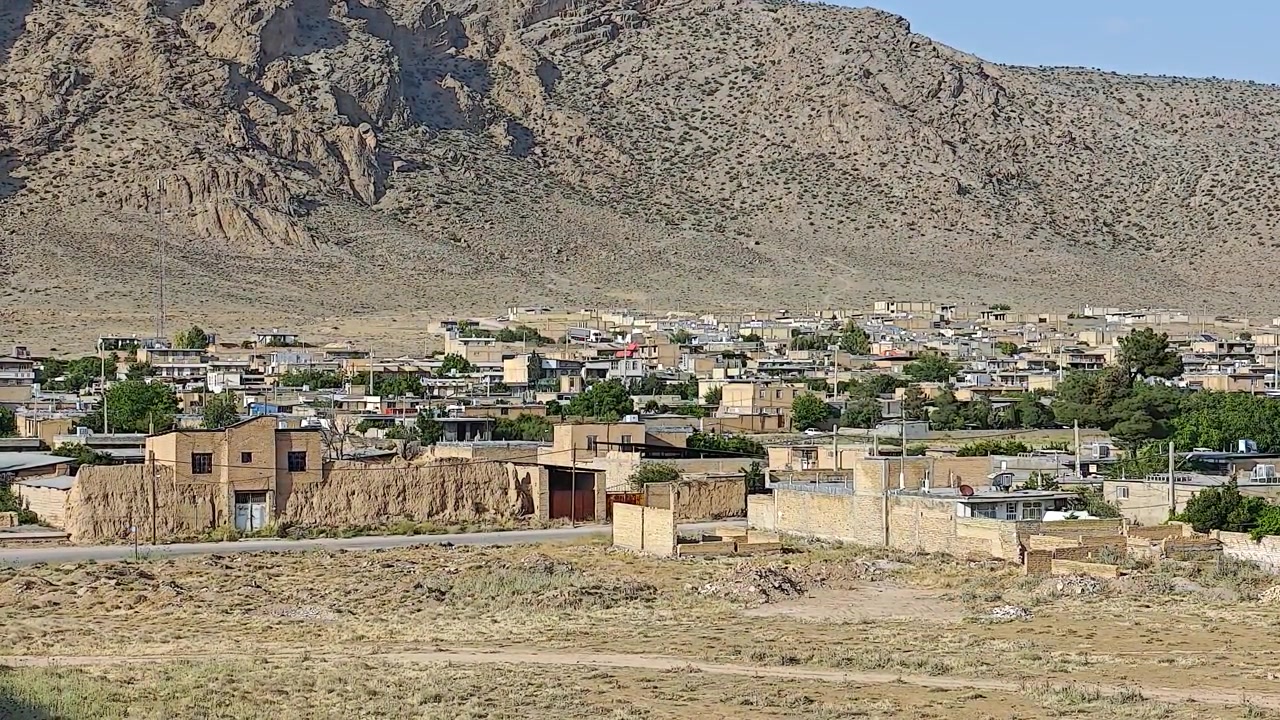 Pequeño pueblo desértico anidado al pie de una montaña rocosa